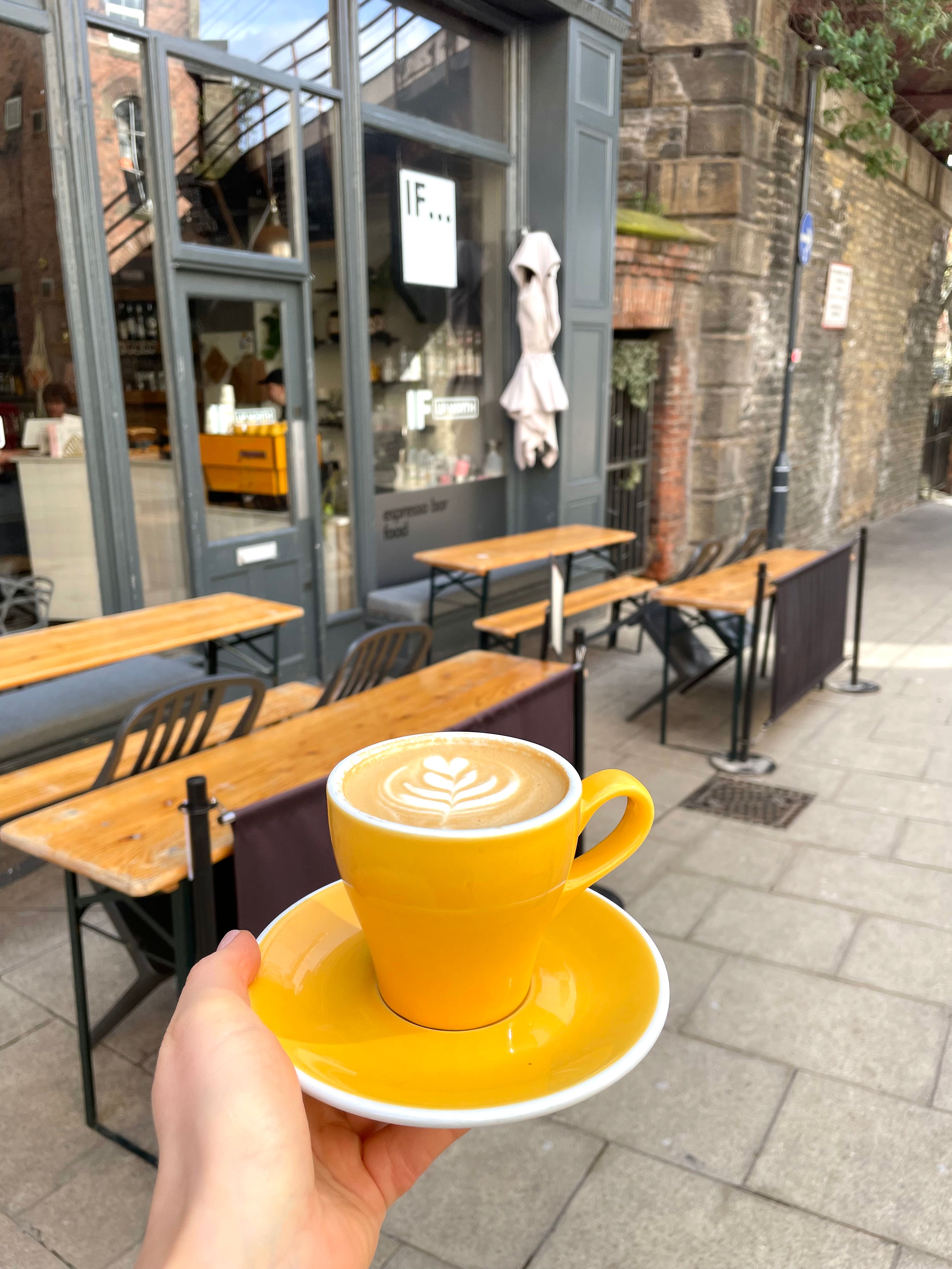 Coffee in yellow cup outside IF Up North shop